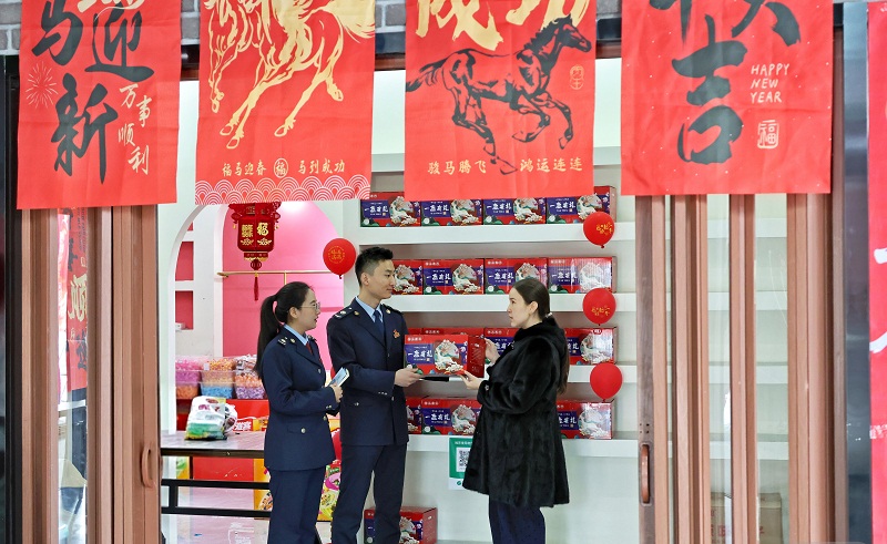 图为 国家税务总局博乐市税务局组织服务队走进“非遗贺新春·寻味中国年”年货大集，为参展商户送上新春祝福，用服务护航浓浓年味儿。（何春英摄1）.jpg