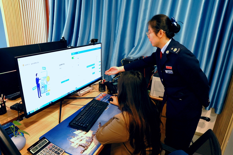 图为：税务干部为“税费服务体验师”讲解电子税务局操作知识（拍摄者：马艺璇）.jpg
