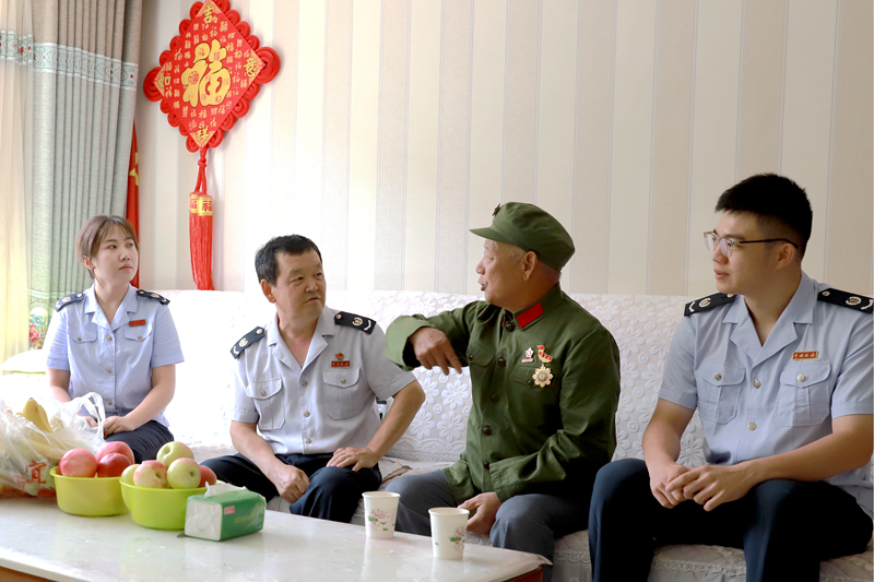 图为 和静县税务局干部倾听退伍老兵讲述革命先辈的光荣事迹.jpg