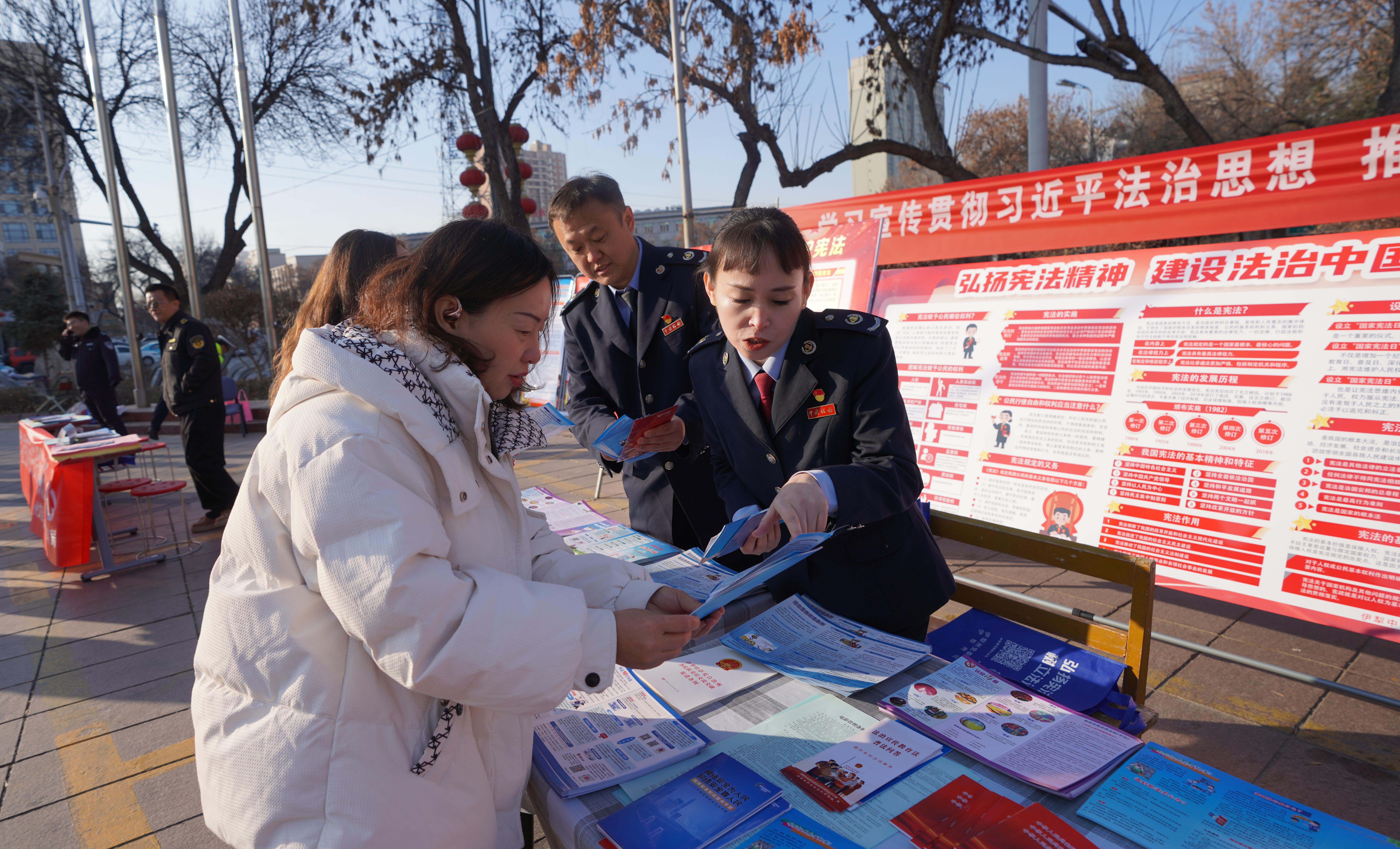 伊犁州税务干部为参加集中普法宣传活动市民送政策　.JPG